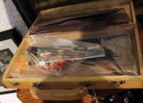 A vintage wooden tackle box containing a selection of vintage floats and quills
