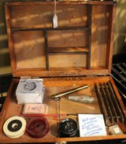 A wooden tackle box containing a boxed Craddock-Astwood Flo 151 fly reel and other accessories