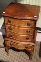 A small reproduction chest of four drawers on legs