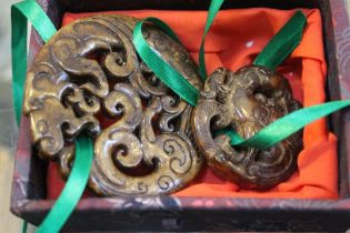 Twin jade carved pendants, the larger with dragon design & second with a phoenix