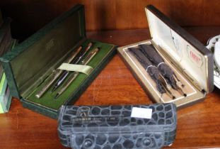 A selection of Cross pens and pencils in two cases with a Hohner cased harmonica