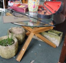 A circular glass top table on substantial wooden base