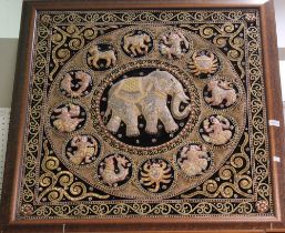 An Eastern style woven silk embroidered panel with central elephant motif, framed