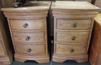 A pair of modern light oak bow fronted three drawer chests