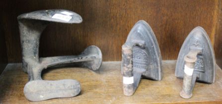 A cast iron shoe last and two cast iron flat irons