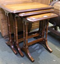 A nest of three dark wood tables