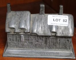 A pewter Ann Hathaway's Cottage money box