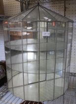 A leaded glass semi-circular display cabinet