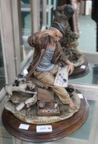 A Capo di Monte ceramic figure of an artist with sketchbook and dog