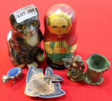 A Whinstanley type seated kitten, 15cm high, two Wade items, a pig pin cushion and a Russian Doll (5