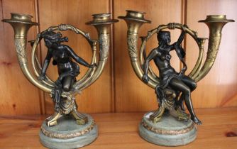 A pair of Art Nouveau design bronze & ormolu table candlesticks in the form of semi-clad ladies with