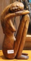 A wood carved sculpture of a seated woman 36cm high