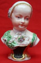 A 19th century Vienna porcelain bust of a child, painted in colours and gilded 14cm high