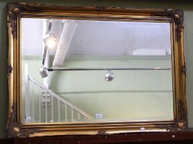 A modern bevel edged mirror in a fancy gilt frame