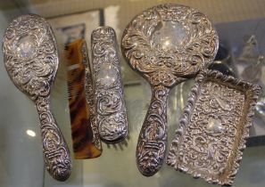 Silver mounted dressing table items, comprising a hand mirror and two brushes with Green Man embosse
