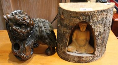 A carved wood Temple Dog with puzzle ball together with a Buddha within a half log niche 21cm high (