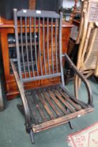 An early 20th century spindle back and slat seated folding chair