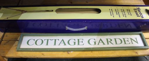 A boxed sketch easel with a cottage garden sign