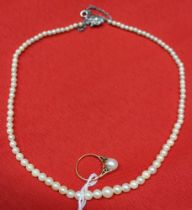 An 18ct gold ring set a solitaire pearl, together with a graduated single strand pearl necklace (2)