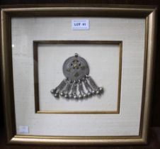 A white metal Arabian hair ornament, worn by girls in Southern Oman, designed as a disc with yellow