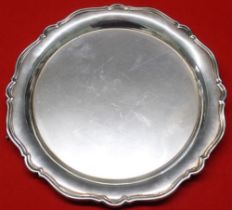 A silver salver of Georgian design, wavy edge, raised on three cast claw feet, Birmingham 1925, 25cm