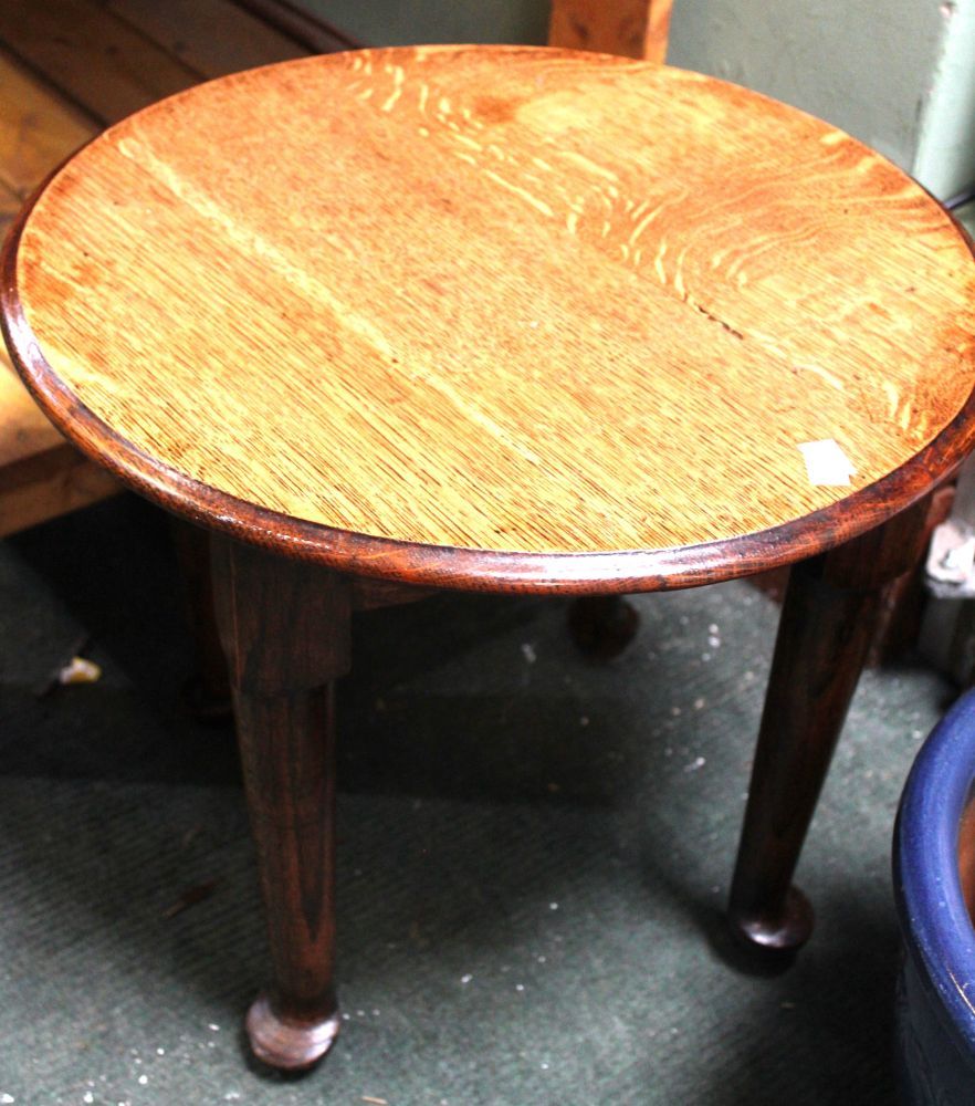 A small circular oak low table on cabriole legs