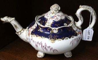 A 19th century china teapot, gilded blue with fancy bird decoration, raised on scallop feet