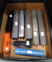 A box containing some early Tri-ang model railway rolling stock and assorted engines