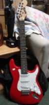 A Rockjam electric guitar finished in red, together with a Rockjam 10W amp