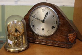 An oak case mantle clock with glass domed anniversary clock