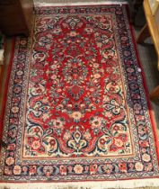 A red ground geometric patterned floor rug