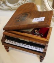 A treen wooden musical jewellery box fashioned in the shape of a grand piano containing