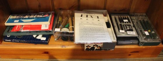 A shelf containing a selection of calligraphy pens accessories etc