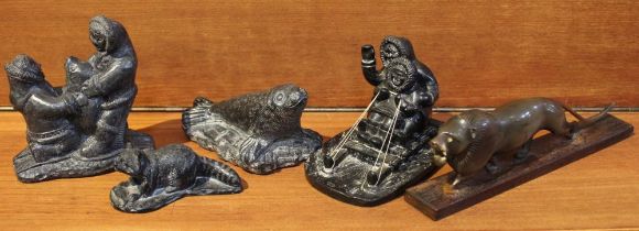 A collection of four Inuit carved figures & a carved horn lion