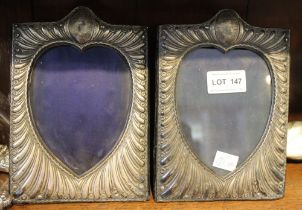 A pair of silver mounted photograph frames, embossed decoration, the image revealed in a heart shape