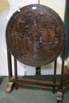 An Oriental carved tilt top table