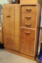 A mid century light oak E.Gonne G-Plan small compactum wardrobe with sliding mirror to top drawer