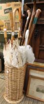 A collection nine of old walking sticks and parasols in wicker stand