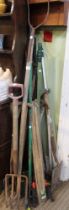 A collection of vintage wooden handled garden tools, canes etc
