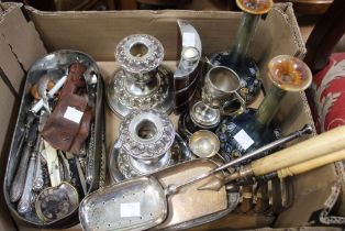 A box containing a selection of silver plate items including candle sticks plated wares and a pair