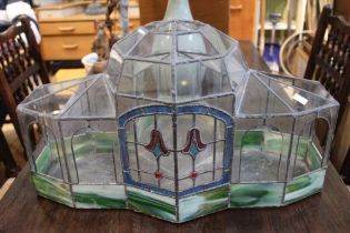 A leaded clear and stained glass terrarium in the manor of a winter garden pavilion