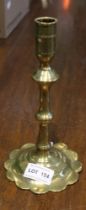 An 18th century brass candlestick with petal shaped base 21cm high