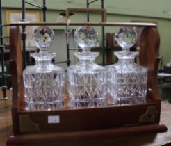 An Edwardian design triple spirit decanter Tantalus, brass mounted mahogany, with key