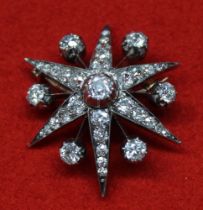 A Victorian diamond brooch, six pointed star shape, silver and gold frame, having a central round ol