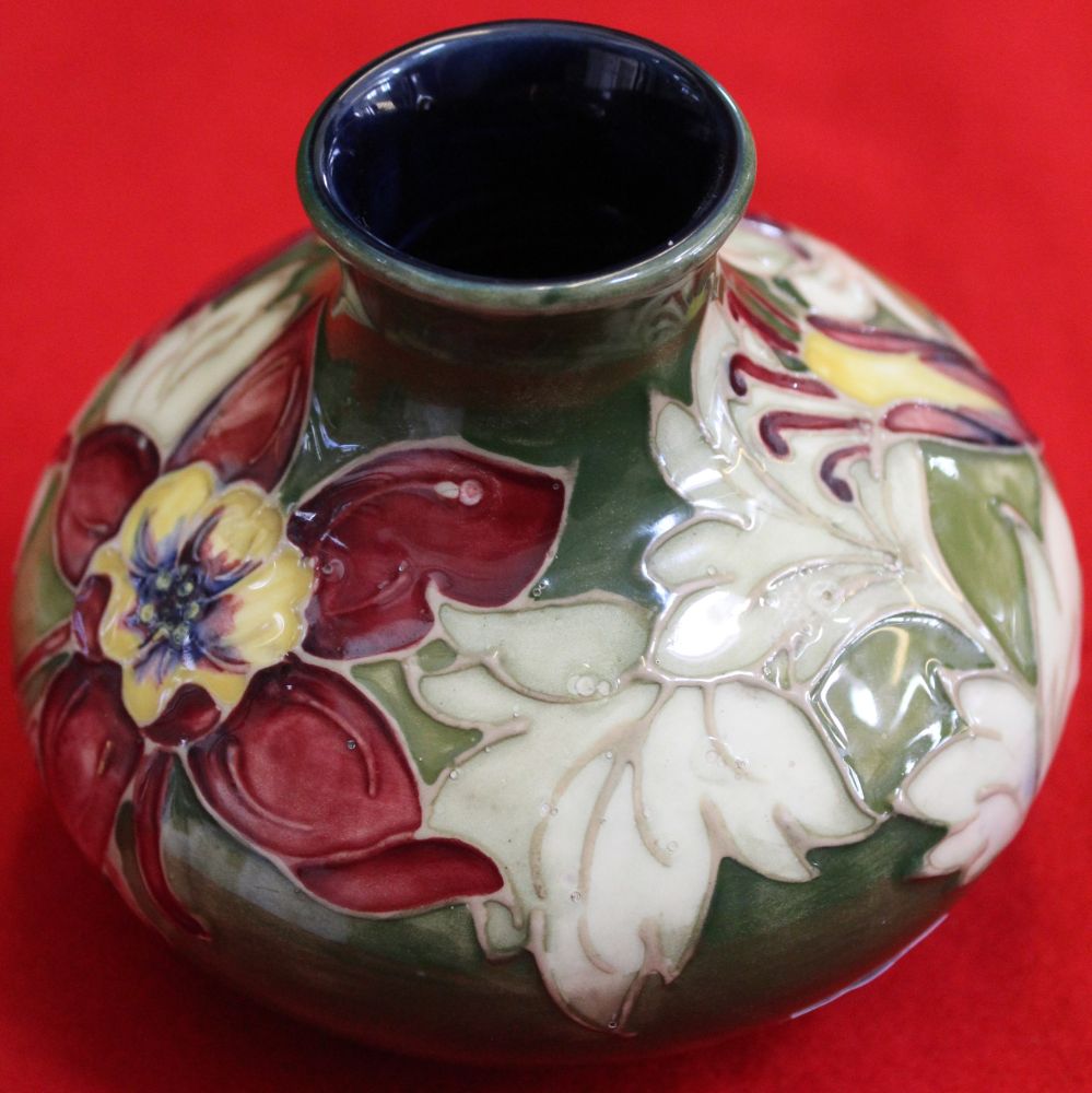 A Moorcroft pottery vase of squat form, tube lined and painted Lily design on a green ground, 10.5cm - Image 2 of 3