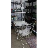 A garden square metal bistro table with two folding chairs