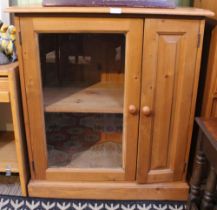 A pine cabinet with glass door and secondary pine door