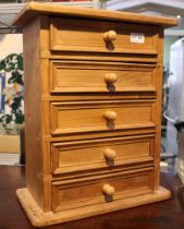 A small pine table top chest of five drawers