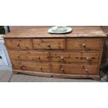A low pine chest of seven drawers 152 x 46 x 73 cm