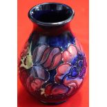 A Moorcroft pottery vase of baluster form, tube lined and painted Anemone design on a blue ground, 1